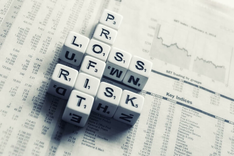 Un crucigrama hecho con dados con letras que deletrean "PROS", "RISK" y "LUCRE" se coloca en un periódico financiero que muestra datos numéricos y un gráfico del mercado de valores, destacando las complejidades de gestionar el riesgo empresarial en Buenos Aires.