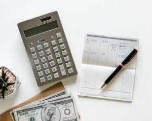 Calculator, book and pen on desk