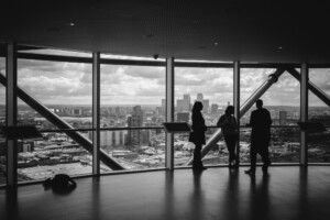 Three people standing in a high-rise building 