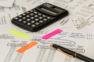 A fiscal entity health check of a Colombian company showing a calculator on a table with a pen and some papers about financial things.