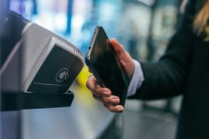 Image showing a man doing a digital payment via his phone to buy something. 