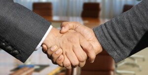 Two persons shaking hands to illustrate the importance of trade agreements in Bolivia.