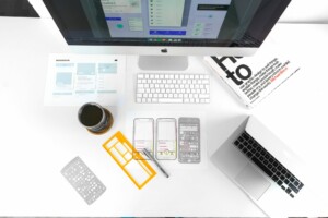 Desk showing graphic design book and drawings of a phone