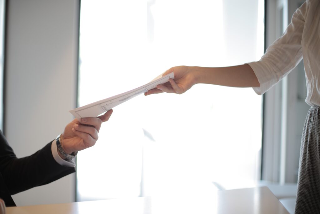 Woman handing a man a document on invoicing requirements for a foreign company in Paraguay 