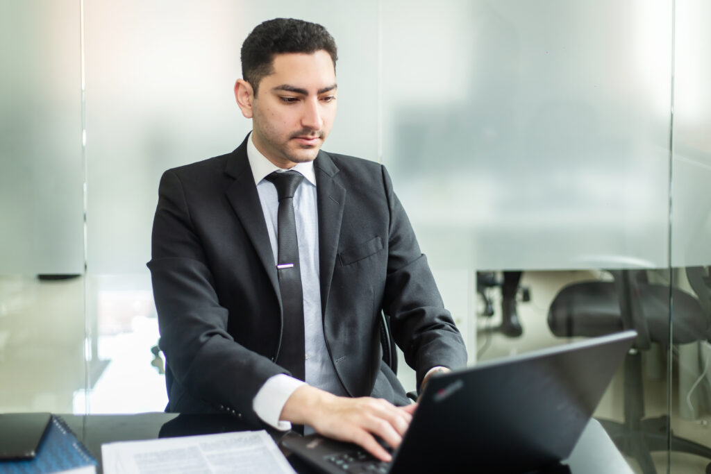 Business man using a laptop, depicting a man searching for information on back office services in Panama. 