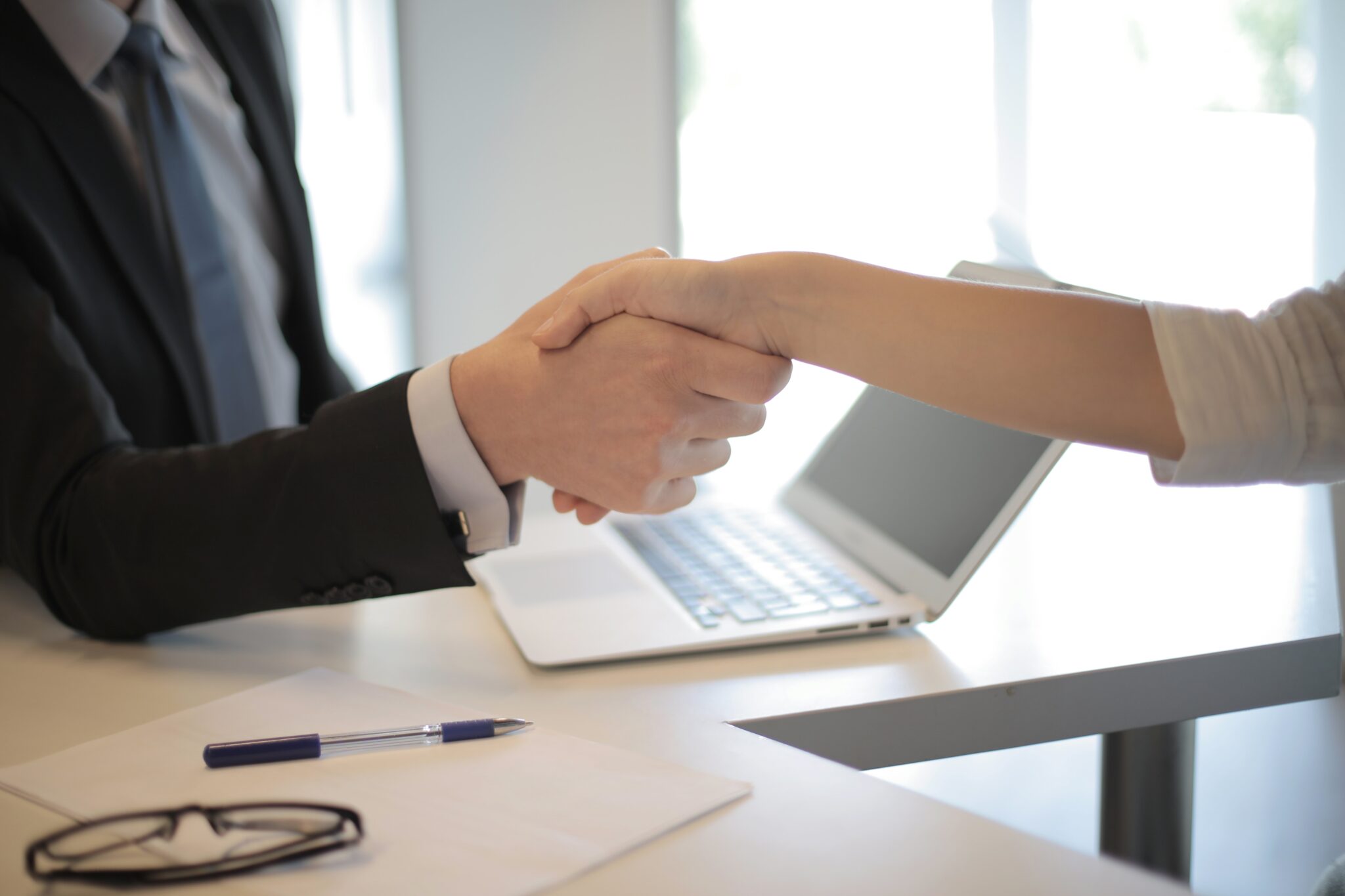 Duas pessoas apertando as mãos, representando duas pessoas falando sobre planejamento tributário corporativo.