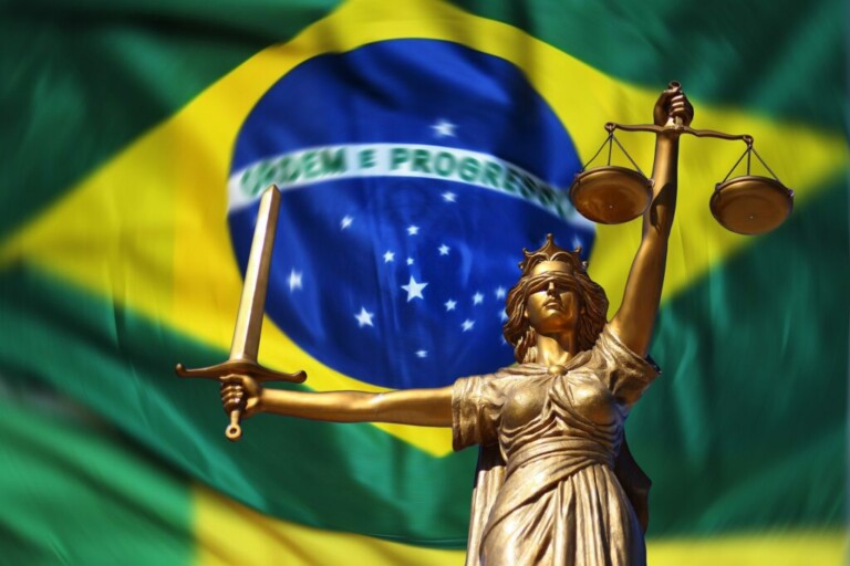 A bronze statue of Lady Justice holding scales in her left hand and a sword in her right stands resolutely in front of a large Brazilian flag with the slogan "Ordem e Progresso." This powerful image underscores the importance of Direito do Trabalho no Brasil.