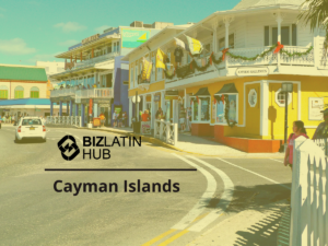 A street scene in the Cayman Islands features colorful buildings, including shops and cafes. A white car is driving on the road, and pedestrians are walking along the sidewalk. The BizLatin Hub logo and text "Cayman Islands" are overlaid on the image, highlighting connections to Investimento Estrangeiro Direto no Brasil.