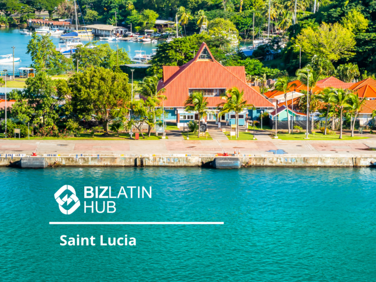 A picturesque waterfront scene in Saint Lucia featuring a red-roofed building surrounded by lush greenery and palm trees. The turquoise water in the foreground contrasts with the vibrant colors. A logo and text reading "BIZLATIN HUB" and "Saint Lucia" are superimposed, highlighting Investimento Estrangeiro Direto no Brasil.