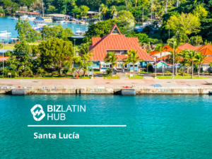 A colorful coastal scene featuring a prominent red-roofed building with lush greenery and a marina in the background. The water in the foreground is a vibrant shade of blue. The image includes the text "Bizlatin Hub - Santa Lucía," highlighting company formation in Saint Lucia.