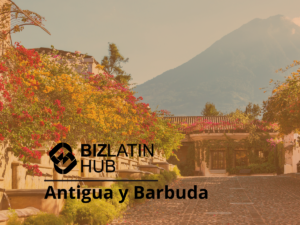 Una vista panorámica de Antigua y Barbuda con un camino adoquinado bordeado de flores y vegetación vibrantes. Al fondo hay una montaña y "Biz Latin Hub" está escrito con un logotipo encima de "Antigua y Barbuda bufete jurídico en Panamá" en la parte inferior central de la imagen.