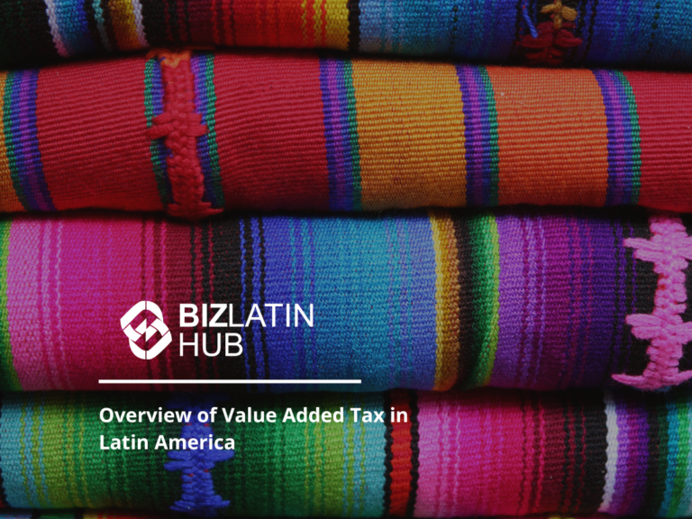 Four folded woven textiles in vibrant colors including red, orange, green, pink, and purple are stacked. The logo "BizLatin Hub" appears in the bottom left with the text "Overview of VAT in Latin America" below it.