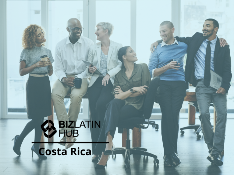 A group of six people dressed in business casual attire are standing and sitting in an office setting, smiling and holding coffee cups. The words "BizLatin Hub" and "Costa Rica" are overlaid on the image, reflecting the latest hiring trends in Costa Rica.