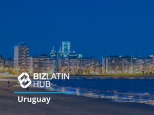 A night view of a coastal city in Uruguay, featuring high-rise buildings along the shoreline. The BIZLATIN HUB logo and the word "Uruguay" are displayed prominently in the foreground, emphasizing Uruguay's business potential. The sky is dark, and the buildings are illuminated with city lights.