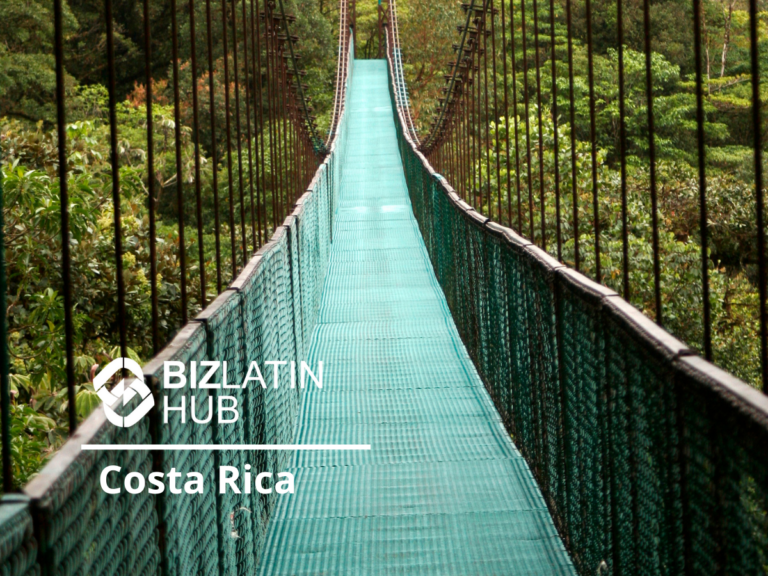 A long, narrow suspension bridge with a green pathway stretches into a lush, green forest. A logo featuring a circular design next to the text "BizLatin Hub Costa Rica" is overlaid on the left side of the image, highlighting opportunities for nearshoring na Costa Rica.