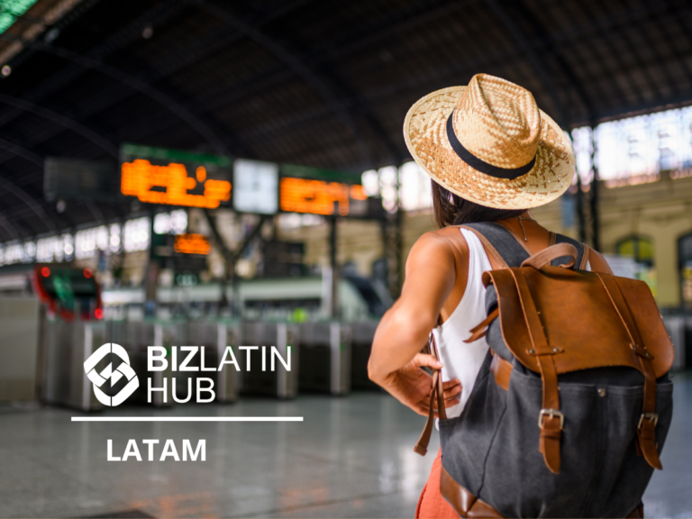 A person wearing a straw hat and backpack stands in a large, arched train station looking at the departure boards, perhaps planning their travels around public holidays in Latin America. The words "BIZLATIN HUB LATAM" are displayed in the bottom left corner of the image.