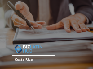 Close-up image of a person’s hands while writing with a pen on documents placed on a table. The photo includes the logo and text "Biz Latin Hub" and "Costa Rica" at the bottom, highlighting their expertise in legal services in Costa Rica.