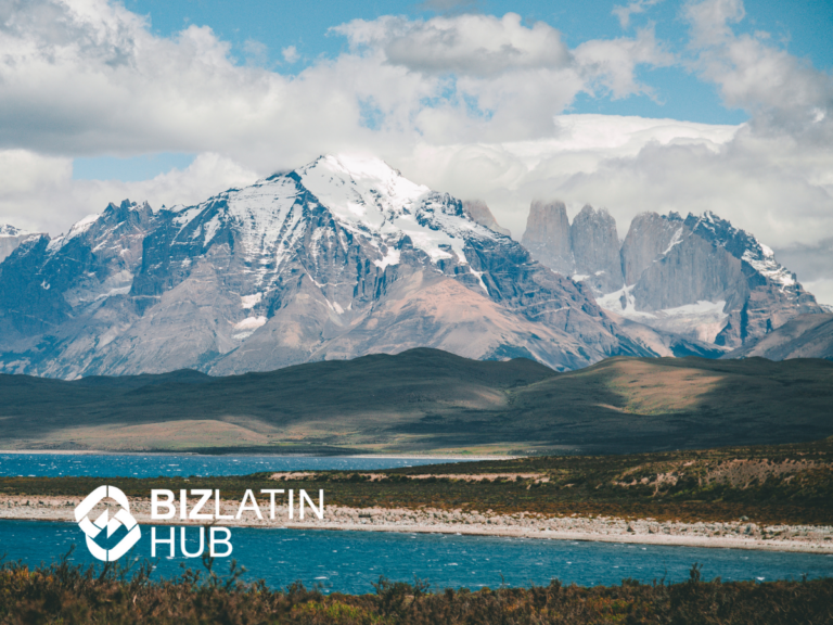 A vast mountainous landscape with snow-capped peaks under a cloudy sky. In the foreground, a large body of water stretches across the image, reflecting Chile's economic landscape. The Biz Latin Hub logo is in the bottom left corner of the image.