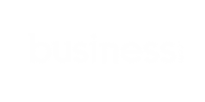 The image shows the logo of business.com. The logo features the word "business" in all lowercase letters, with ".com" written vertically next to the letter "s". The text, often associated with fields like recruitment and accounting, is white on a transparent background.